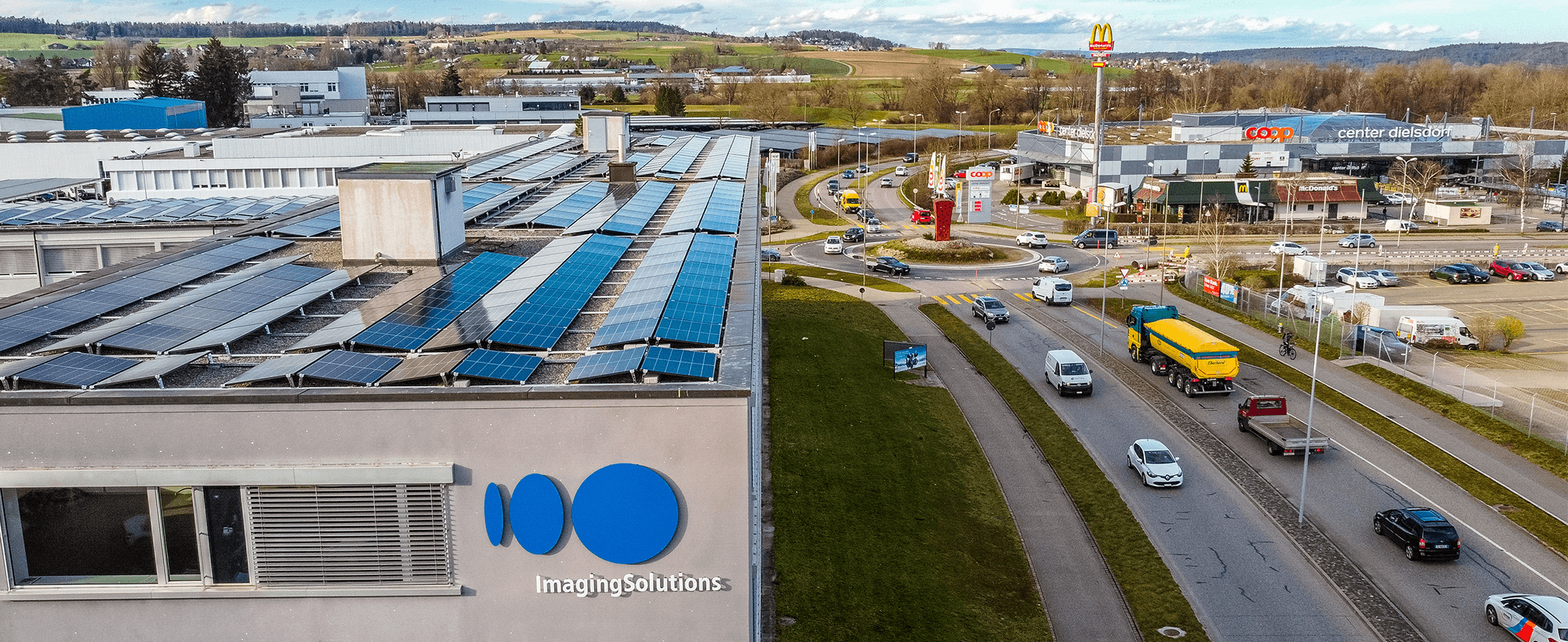 Viesus headquarters and Imaging Solutions office in Dielsdorf, Zurich, with visible solar panels and surrounding commercial area.