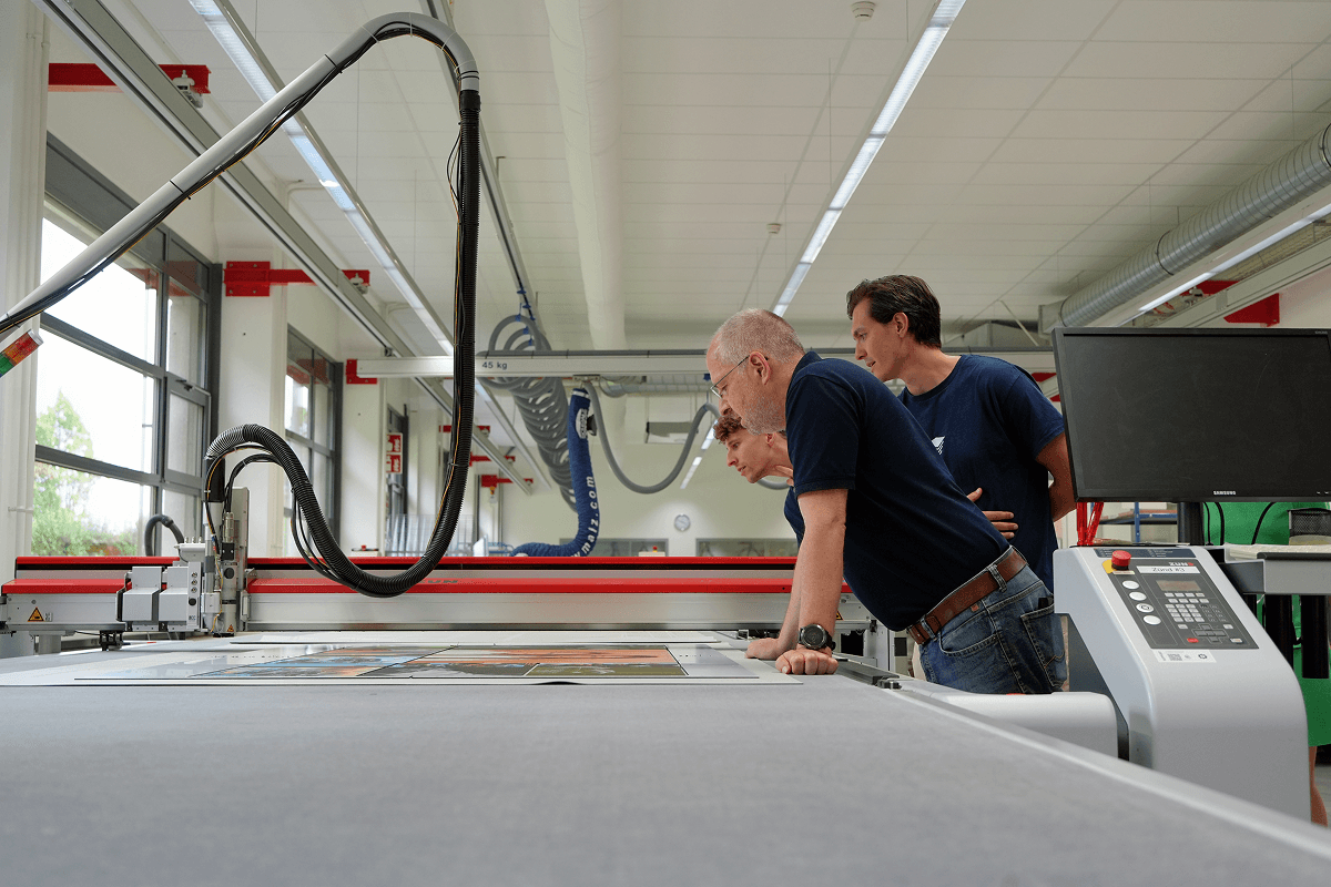 Viesus and ifolor team members reviewing large-format wall decoration prints on Aluminum Dibond in the production area